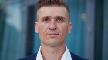 a man in a suit and white shirt standing outside video