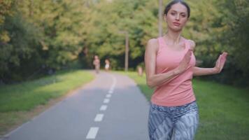 un mujer es corriendo en un camino en el parque video