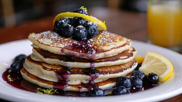 A stack of pancakes with blueberries on top photo