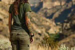 un mujer con tatuajes en su brazo soportes en un Desierto paisaje foto