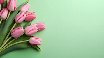 Bouquet of pink tulips on green background, top view, with copy space for text. Greeting card for Valentine's Day, Woman's Day, Mothers day photo