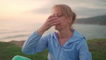 senior kvinna praktiserande yoga övning på de strand. video