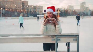 ung leende kvinna is skridskoåkning inuti på is rink. video