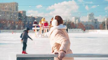 ung leende kvinna is skridskoåkning inuti på is rink. video