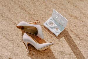 wedding shoes on the sand, wedding rings photo