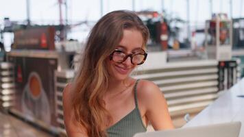 een vrouw in bril zittend Bij een tafel met een laptop. afgelegen werken concept video