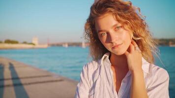 femme porter blanc chemise avec frisé cheveux permanent près le l'eau video