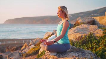 un' donna è fare yoga su il spiaggia video