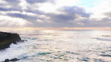 Aerial Drone View of Rugged Rocky Coastline with Waves Crashing and Breaking Against Rocks at Sunrise. video