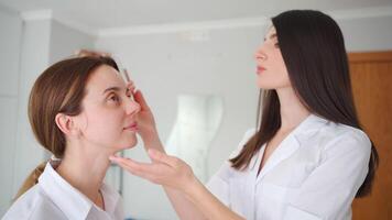 Kosmetikerin Markierung Gesicht zum Füllstoff Injektion. Kosmetikerin Markierung Punkte zum Schönheit Injektionen auf weiblich Gesicht. video