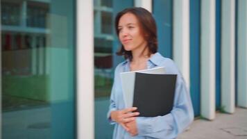 a woman holding a folder and walking video