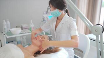 hydropeeling skönhet procedur, rengöring ansikte, rena hud. kvinna patient i kosmetologi klinik, läkare utför skönhet procedur i kosmetologi klinik, kosmetolog rengöring patientens ansikte video