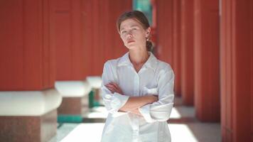 uma mulher dentro uma branco camisa em pé dentro a esvaziar corredor video