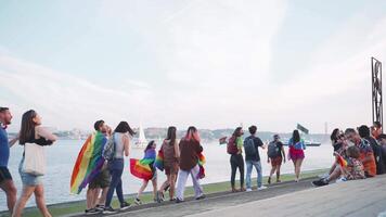Lissabon, portugal. 17 juni 2023. HBTQ människor avkopplande på promenad njuter segelbåtar på stolthet parad. video