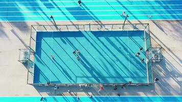 Aerial view of the city public basketball and football court with running track. video