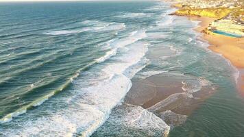 aéreo Visão do onda em a de praia com areia e turquesa ondas video