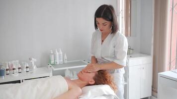een vrouw krijgen een gelaats massage in een schoonheid salon video