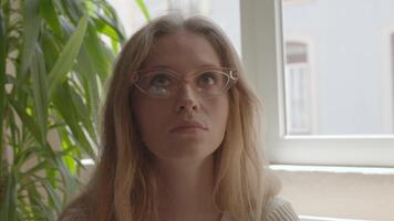 a woman with glasses looking up at the camera video