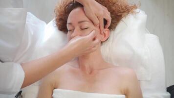 un' donna ottenere un' facciale massaggio nel un' bellezza salone video
