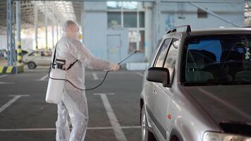 a man in a white protective suit is spraying a disinfectant video