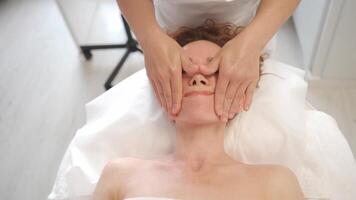 a woman getting a facial massage in a beauty salon video