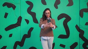 un mujer tomando un selfie en frente de un verde pared video