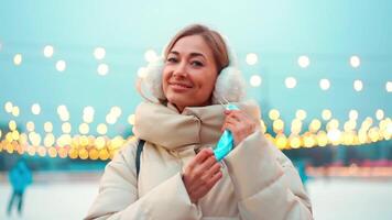 une femme dans une hiver manteau permanent proche à la glace patinoire video