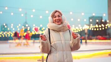 a woman in a winter coat standing close to ice rink video