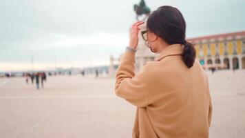 un' donna nel un' abbronzatura cappotto è guardare a qualcosa video