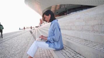 Businesswoman use laptop outdoor sitting stairs background. Caucasian female business person 30 years typing laptop keyboard. Remote work freelancer concept. Freelance job its new normal video