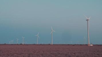 vento turbine rotante e generando verde ecologico energia. vento azienda agricola nel un' verde paesaggio. sostenibile energia per il bene di il pianeta e natura video