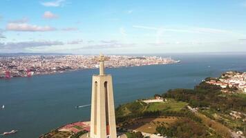 Lissabon, portugal 27 juni 2023 christ de kung, almada, portugal. panorama lissabon stad med skön landmärken. antenn se tagus flod och 25 de abril bro i bakgrund blå himmel video