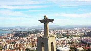 Lisbon, Portugal 27 June 2023 Christ the King, Almada, Portugal. Panorama Lisbon city with beautiful landmarks. Aerial view Tagus River and 25 de Abril Bridge in background blue sky video