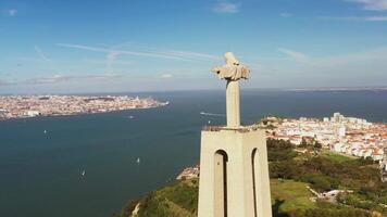 Lissabon, portugal 27 juni 2023 christ de kung, almada, portugal. panorama lissabon stad med skön landmärken. antenn se tagus flod och 25 de abril bro i bakgrund blå himmel video