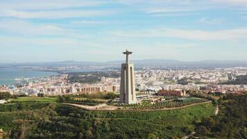 Lissabon, portugal 27 juni 2023 christ de kung, almada, portugal. panorama lissabon stad med skön landmärken. antenn se tagus flod och 25 de abril bro i bakgrund blå himmel video