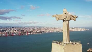 Lisbon, Portugal 27 June 2023 Christ the King, Almada, Portugal. Panorama Lisbon city with beautiful landmarks. Aerial view Tagus River and 25 de Abril Bridge in background blue sky video