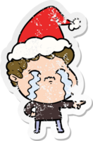 hand drawn distressed sticker cartoon of a man crying wearing santa hat png