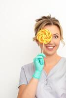 Beautiful smiling beautician holding fresh pineapple and cover her eye with lollipop over white background. Skincare cleansing eco organic. photo