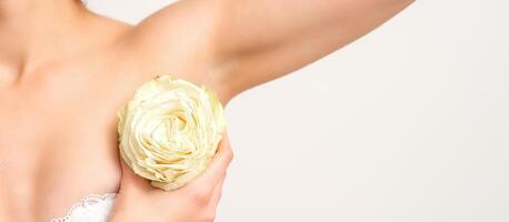 Close up of female armpit with white rose flower isolated on white background. photo