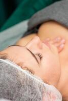 Massaging female chest. Young beautiful caucasian woman with closed eyes getting chest massage at beauty spa salon. photo