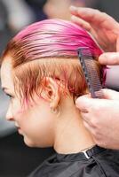 peinado hembra cabello. masculino peluquero hace peinado para un joven mujer en un belleza salón. foto