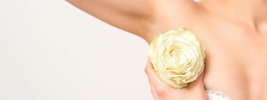 Close up of female armpit with white rose flower isolated on white background. photo