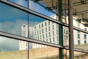 a house is reflected on a window of an exterior facade photo