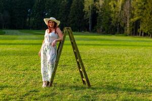 mujer en mono con un blanco vestir en un prado foto