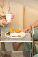 Young caucasian woman consulting with two masseurs during tea with dried fruit in the massage spa. photo