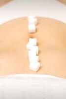 Sugar cubes lying in a row on abdomen of young woman, the concept of intimate depilation, problems of intimate hygiene. photo