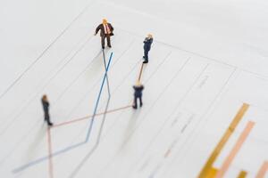 A group of miniature businessman looking at line chart photo