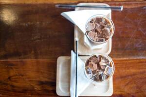 Two iced mocha coffee. Espresso coffee mixed chocolate on wooden table in cafe. photo