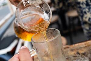 mano de barman torrencial cerveza a vaso foto