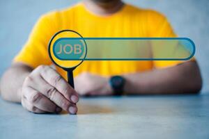 Man hold magnifying glass to find information on the internet online, job searching. photo